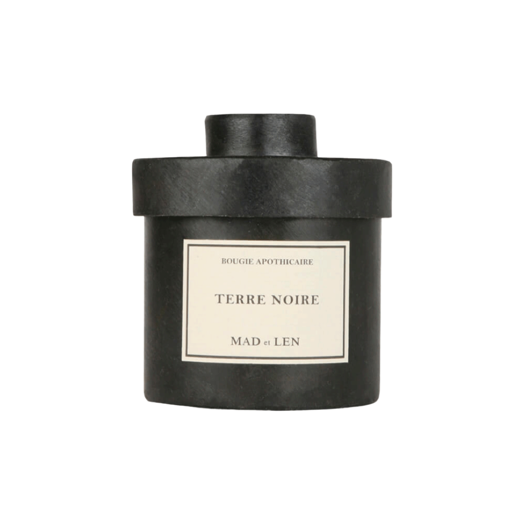 Bougie Parfumée Terre Noire de MAD et LEN est composé de terre primal, humus, écorce, bois pétrifié, cèdre, champignon et sous bois. Conçu pour 65h de combustion à base de cire blanche 100% végétale