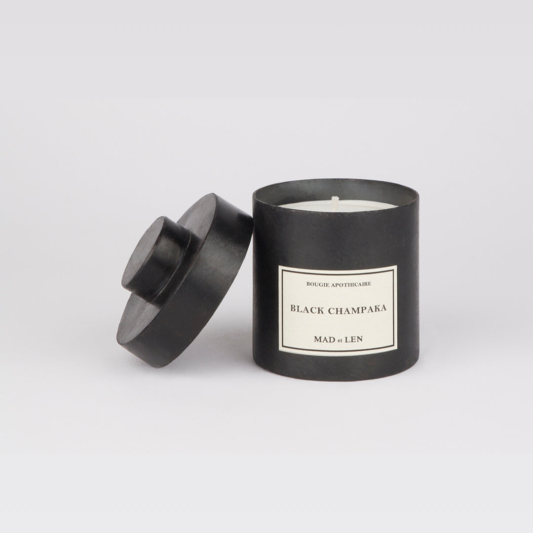 Bougie Parfumée Black Champaka de MAD et LEN est composé de terre primal, humus, écorce, bois pétrifié, cèdre, champignon et sous bois. Conçu pour 65h de combustion à base de  cire blanche 100% végétale